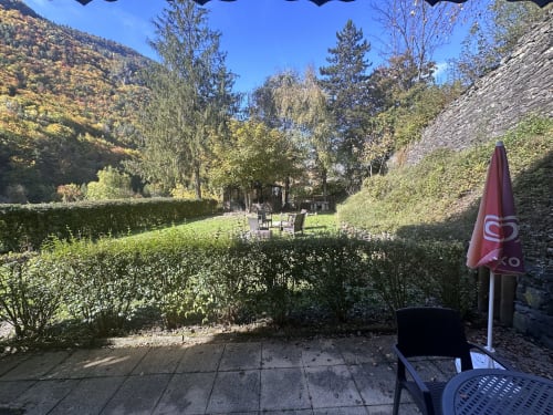 Terrasse de station de montagne à l'Hôtel Studios La Rochetaillée à Brides-les-Bains avec vue alpine, mobilier et parasol