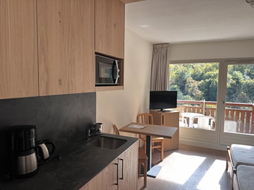 Kitchenette moderne et séjour avec vue sur les montagnes aux Studios La Rochetaillée, Brides-les-Bains