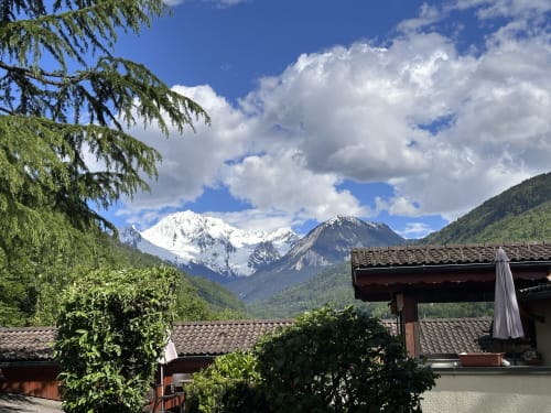 Vue sur les Alpes enneigées depuis l'Hôtel Studios La Rochetaillée à Brides-les-Bains avec bâtiments en pierre traditionnels