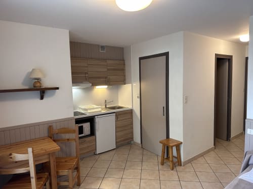 Kitchenette d'un studio à l'Hôtel Studios La Rochetaillée à Brides-les-Bains avec coin repas et équipements modernes