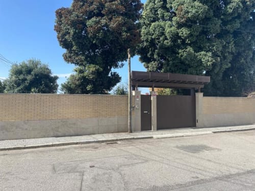 Entrada moderna com portão metálico da Casa Da Avó Ilda B&B em Matosinhos, paredes de tijolos