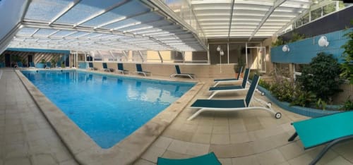 Piscina interior aquecida com espreguiçadeiras e teto de vidro retrátil na Casa Da Avó Ilda, uma casa de hóspedes à beira-mar em Matosinhos, Portugal