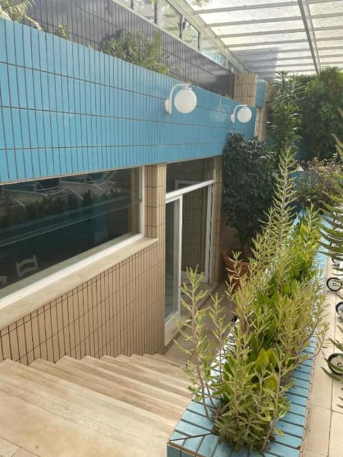 Terraço moderno com toldo azul, piso de madeira, plantas em vasos e portas de vidro na Casa Da Avó Ilda, Matosinhos.