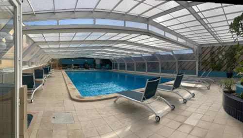 Piscina interior aquecida com espreguiçadeiras sob telhado de vidro na Casa Da Avó Ilda em Matosinhos