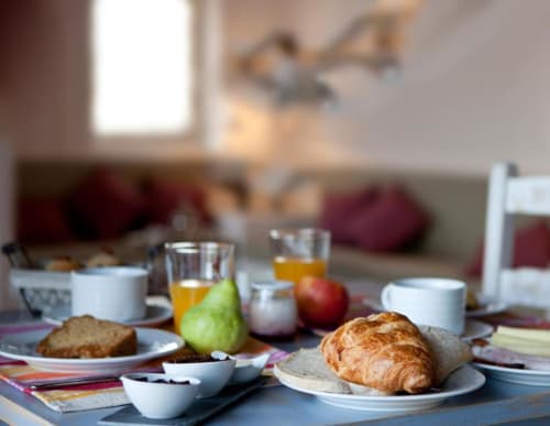 Breakfast table at Home Alliance B&B in Bombarral with croissant, fruit, coffee, and pastries