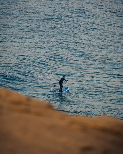 Surfer riding a wave in blue waters near Bombarral, Óbidos, Portugal - Home Alliance beachfront experience