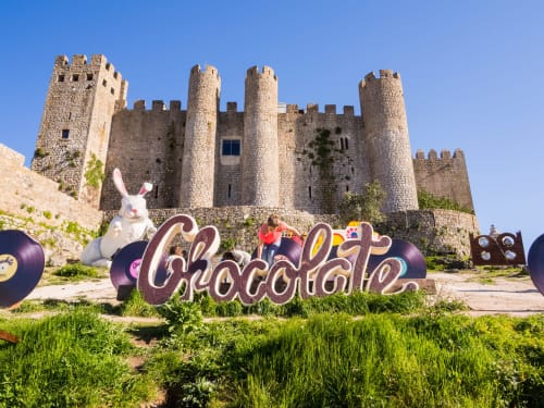 Medieval castle with colorful Chocolate sign and white rabbit sculpture in Óbidos, Portugal near Home Alliance Bombarral