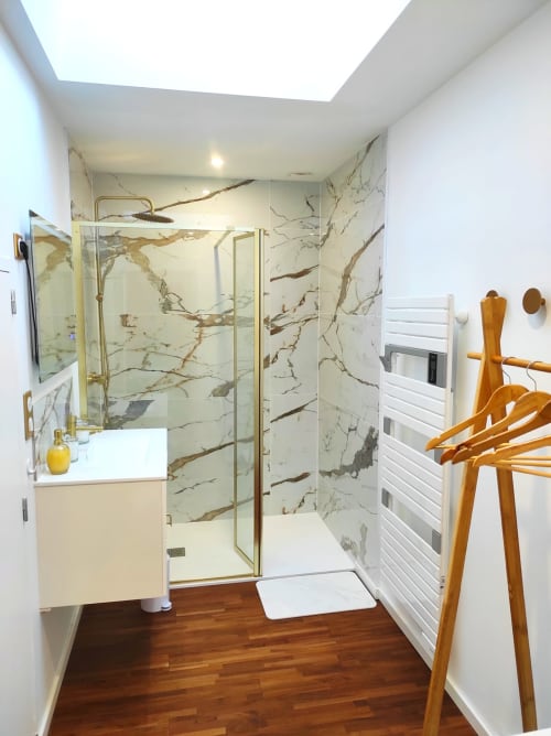 Salle de bain moderne de l'appartement Accolade à Châteaudun avec douche en marbre, parquet et puits de lumière