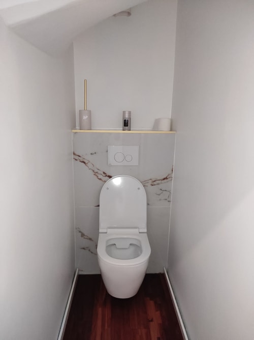 Toilettes blanches modernes avec dosseret en marbre dans la salle de bains de l'appartement Accolade, Châteaudun