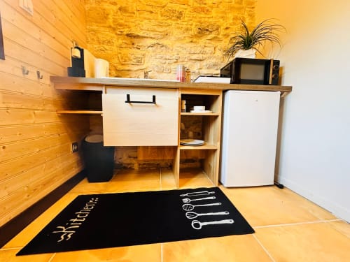 Petite kitchenette équipée dans la chambre Vue Sur Gindou B&B avec mobilier en bois, micro-ondes, mini-frigo et tapis de cuisine