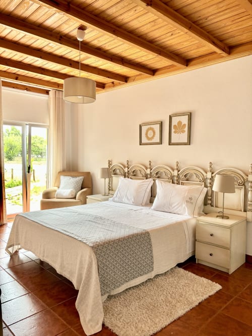 Quarto Duplo Superior at Home Alliance Bombarral with wooden beams, metal bed frame, cream bedding, and terrace access