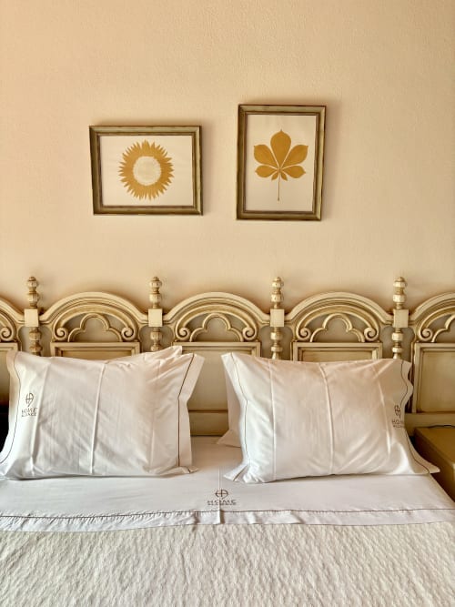 Quarto elegante do hotel boutique Home Alliance em Bombarral com cabeceira de latão trabalhado, almofadas creme e parede botânica