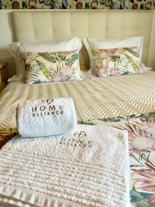 Cama Home Alliance com toalhas brancas bordadas, almofadas florais e roupa de cama às riscas em Bombarral, Óbidos