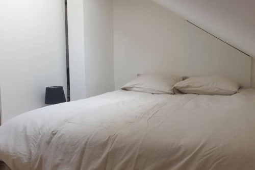 Chambre minimaliste Duplex les Myrtilles Les Carroz avec literie crème et oreillers beige