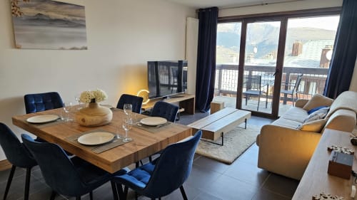 Appartement moderne à L'écrin des sapins avec table à manger, vue montagne depuis le balcon et coin séjour à Aime-la-Plagne