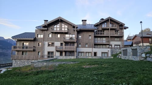 Complexe L'écrin des sapins à Aime-la-Plagne, vue montagne, architecture bois et pierre moderne, verdoyant