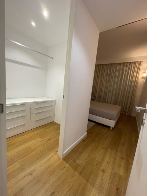 Closet moderno com móveis brancos e vista do quarto no apartamento Casas de Juromenha em Juromenha