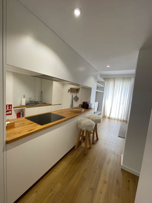 Cozinha moderna no apartamento T1 Cascais Houses em Casas de Juromenha, Juromenha, com bancadas de madeira e barra de refeições