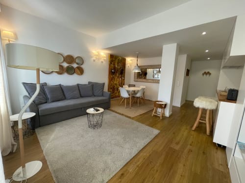 Apartamento moderno de planta aberta em Casas de Juromenha com sofá cinza, sala de jantar e cozinha integrada