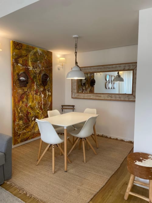 Moderna sala de jantar no apartamento Cascais Houses com cadeiras brancas, mesa de madeira e obra de arte abstrata dourada