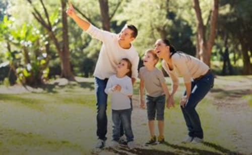 Familia volando cometa al aire libre en el alojamiento rural Can Gat Vell en Girona, Cataluña