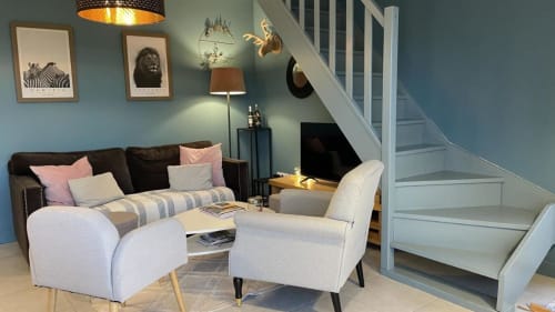 Salon contemporain aux Maisons Le Clos Du Moulin avec fauteuils crème, canapé anthracite et escalier à Entraigues sur la Sorgue