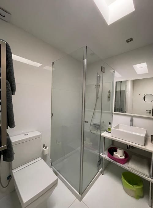 Modern bathroom at Casas de Juromenha with glass shower enclosure, white fixtures, and skylight windows