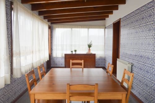 Espaçosa sala de jantar da villa Casa Da Avó Ilda em Matosinhos com mesa de madeira, teto com vigas de madeira e paredes com padrão azul