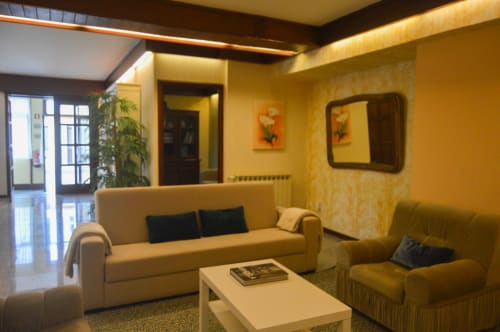 Sala de estar aconchegante em tons de amarelo com sofá e poltrona bege na villa Casa Da Avó Ilda em Matosinhos, Portugal