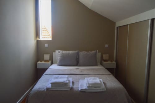Quarto moderno no apartamento Casa Da Avó Ilda, Matosinhos com cama queen, almofadas cinzas, mesas de cabeceira, janela e porta deslizante