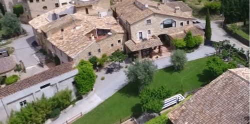 Vista aérea del alojamiento boutique Can Gat Vell en Girona, Empordà con edificios de piedra y jardines cuidados