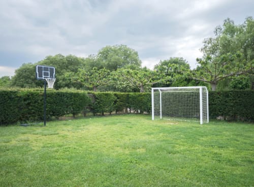 Área de deportes en el patio trasero del alojamiento Can Gat Vell en Girona con canasta de baloncesto y portería de fútbol
