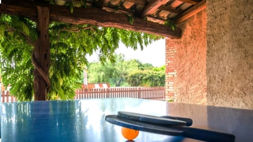 Terraza cubierta de Can Gat Vell B&B en Girona con muros de ladrillo, enredaderas verdes y vistas al valle de Empordà-Catalunya
