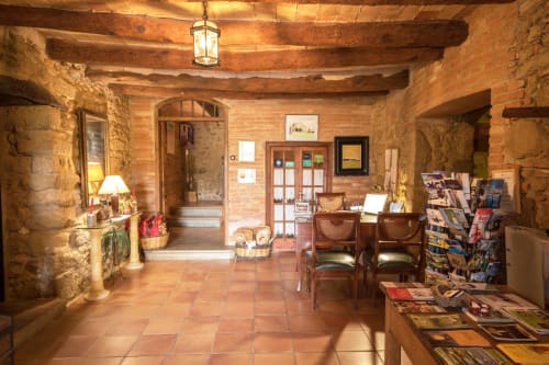 Rústica zona de recepción en Can Gat Vell B&B en Girona, Cataluña, con vigas vistas y suelos de baldosas de terracota