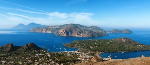 Vista aerea della costa di Taormina con il Mar Mediterraneo, isole e barche ancorate nelle acque blu