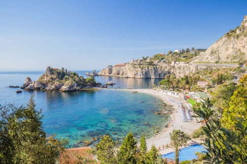 Appartamenti ToviMar affacciano su acque cristalline del Mediterraneo e spiaggia sabbiosa a Taormina, con scogliere spettacolari e