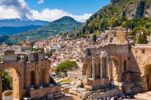 Rovine dell'antico teatro greco che si affaccia sulla città di Taormina con l'Etna sullo sfondo