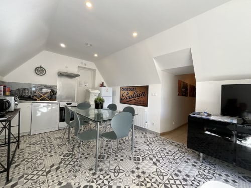 Modern kitchen-dining area in Locacharme's Gîte Auguste Poulain cottage, Blois, with geometric floor tiles and dining table