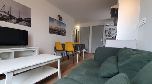 Modernes Cottage-Wohnzimmer in Blois mit grünem Sofa, TV, gelben Stühlen und Flussblick bei Locacharme