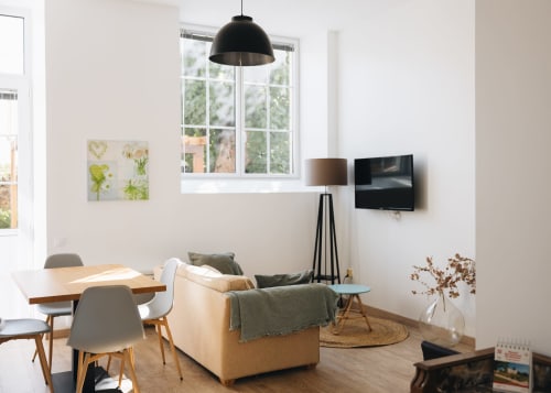 Salon cosy de La Maison D'olivier avec salle à manger, sièges confortables, télévision et grande fenêtre avec vue