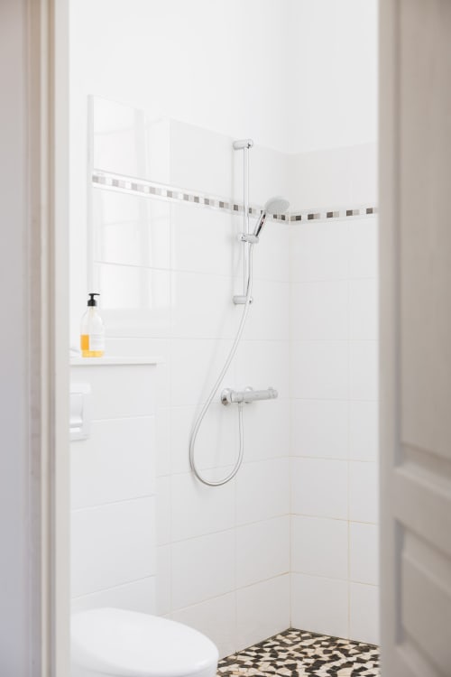 Douche moderne au gîte La Maison D'olivier à Mesnard la Barotière avec carrelage blanc, pommeau de douche cascade et sèche-serviettes chauffant