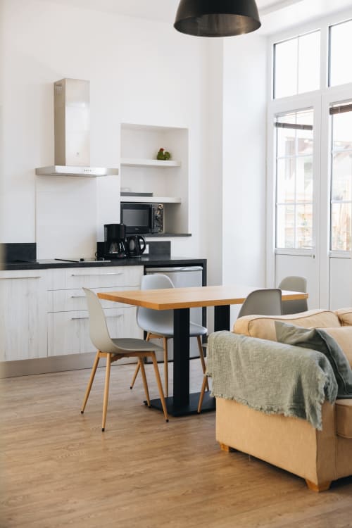 Cuisine ouverte et salle à manger modernes à La Maison D'olivier BnB à Mesnard la Barotière avec table en bois et canapé
