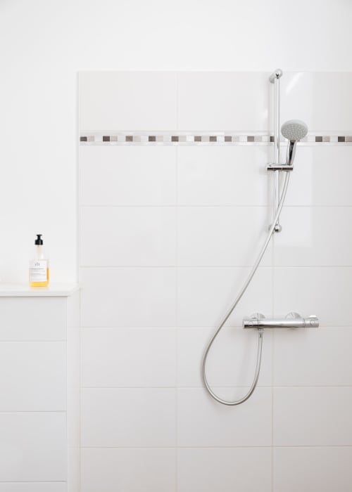 Salle de bain moderne avec carrelage blanc métro, robinetterie chromée et équipements à La Maison D'olivier B&B