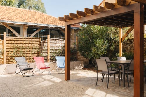 Terrasse extérieure de La Maison D'olivier BnB à Mesnard La Barotière avec pergola en bois, table à manger et chaises longues