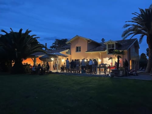 Evening garden party at La Conciergerie Biarritz, illuminated French villa with guests on lawn