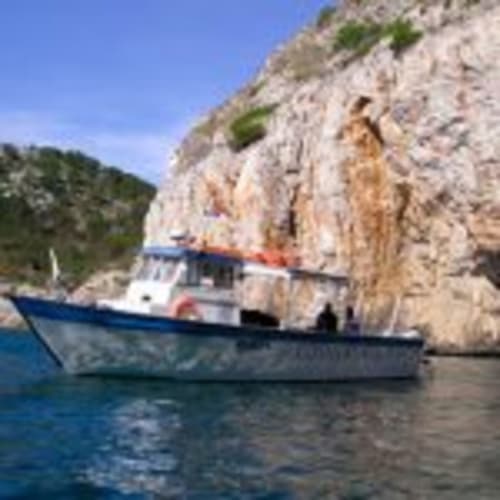 Fishing boat moored near white limestone cliffs in Girona, Empordà, Catalunya - scenic coastal setting near Can Gat Vell