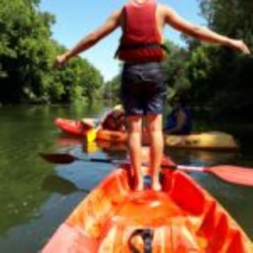 Person balancing on kayak during water activity near Can Gat Vell in Girona