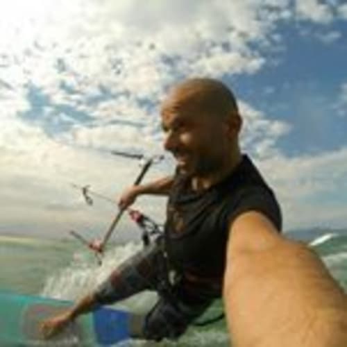 Man kitesurfing on Mediterranean waters near Can Gat Vell, a bed and breakfast in Girona, Catalonia.
