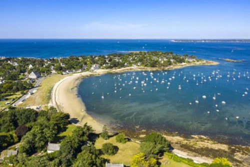 Aerial view of Concarneau's sandy beach and moored sailboats, Les logis de Kergoulou B&B coastal setting