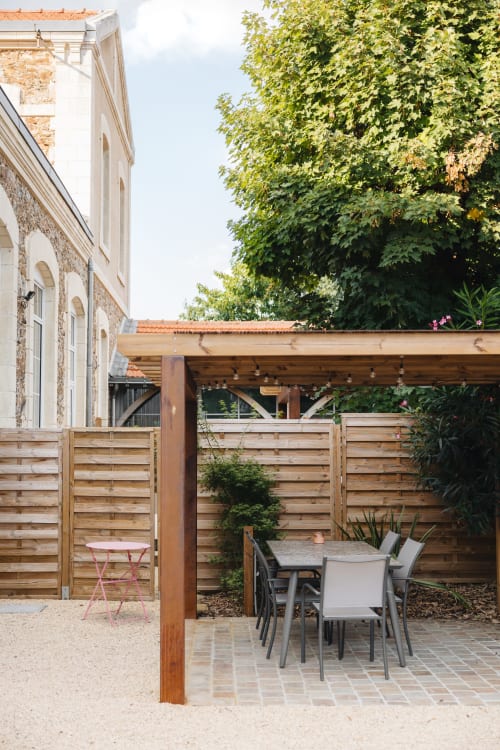 Patio extérieur avec table à manger à La Maison D'olivier B&B à Mesnard-la-Barotière, pergola en bois et jardin